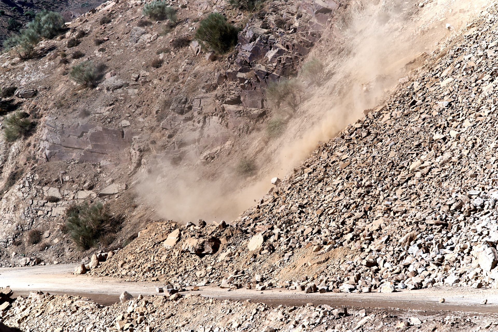 brown rocky slope down to a dirt road